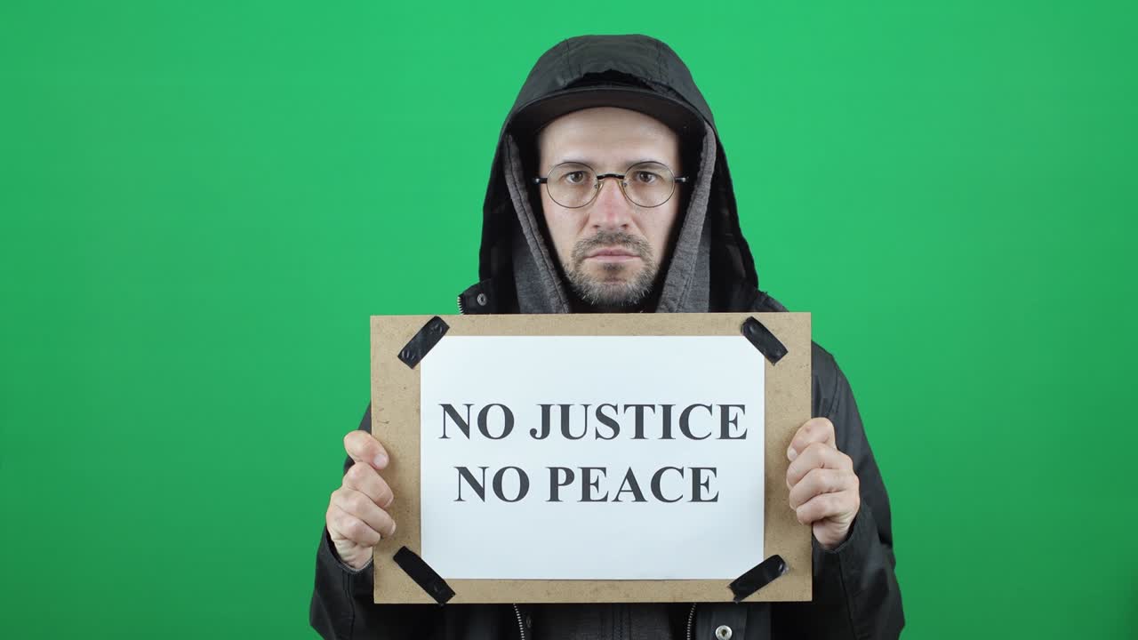 "정의도 평화도 없다""라는 글과 ""정의도 평화도 없다""는 글이 녹색 색 바탕에 새겨진 백인 유럽인 남성"