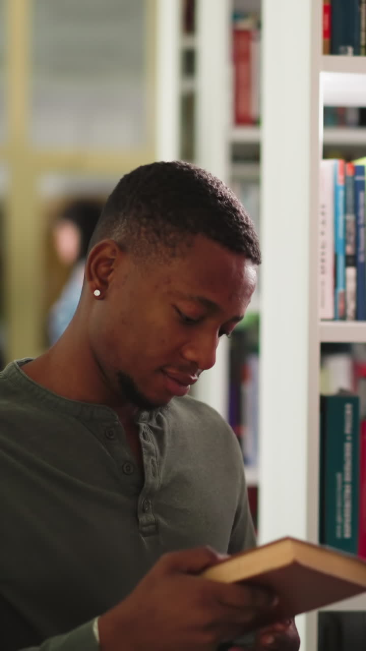 el estudiante recibe libros en la biblioteca pública. el hombre negro toma el folio del bibliotecario visitando el centro de información universitario. literatura para escribir ensayos