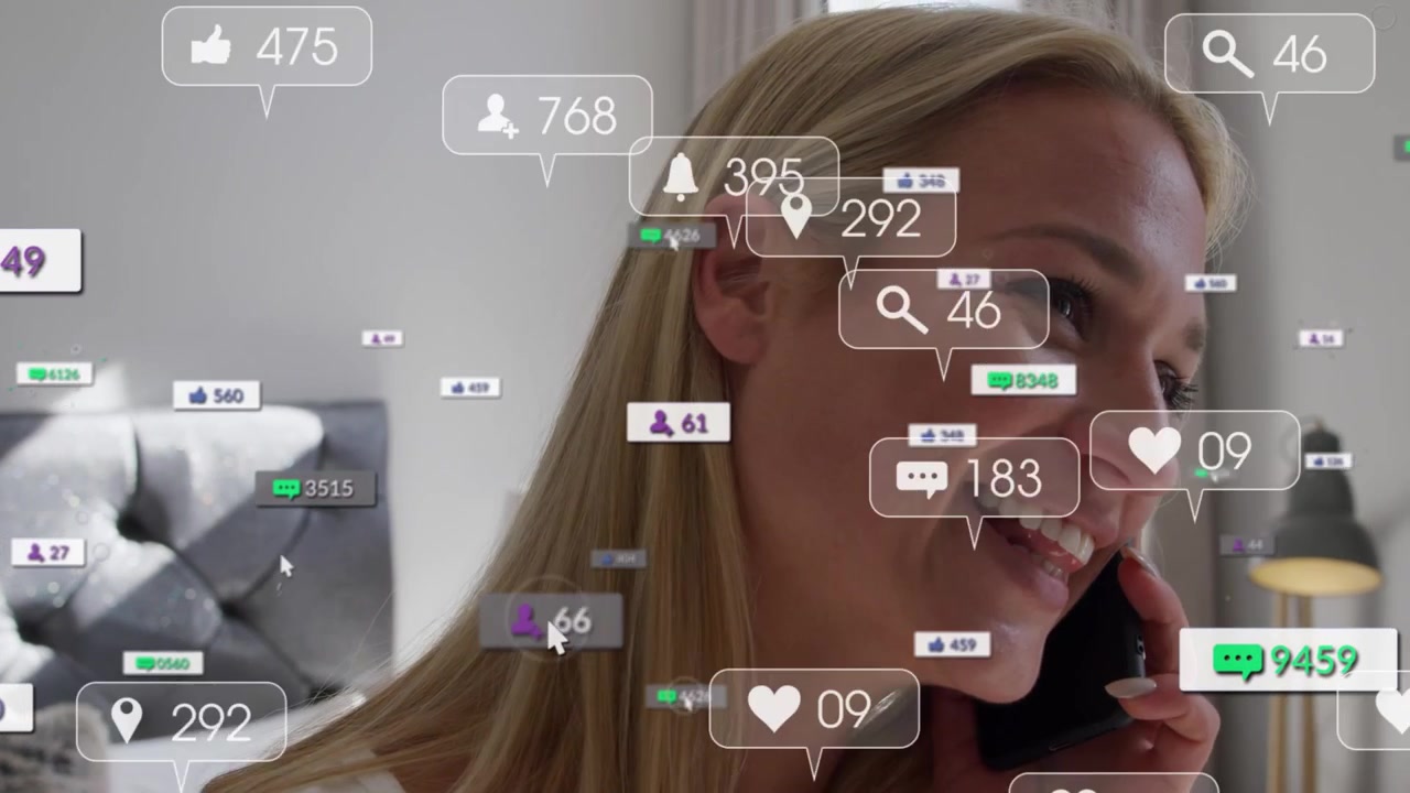 Adult female holding phone in bedroom, call sparking floating likes over face showing social buzz