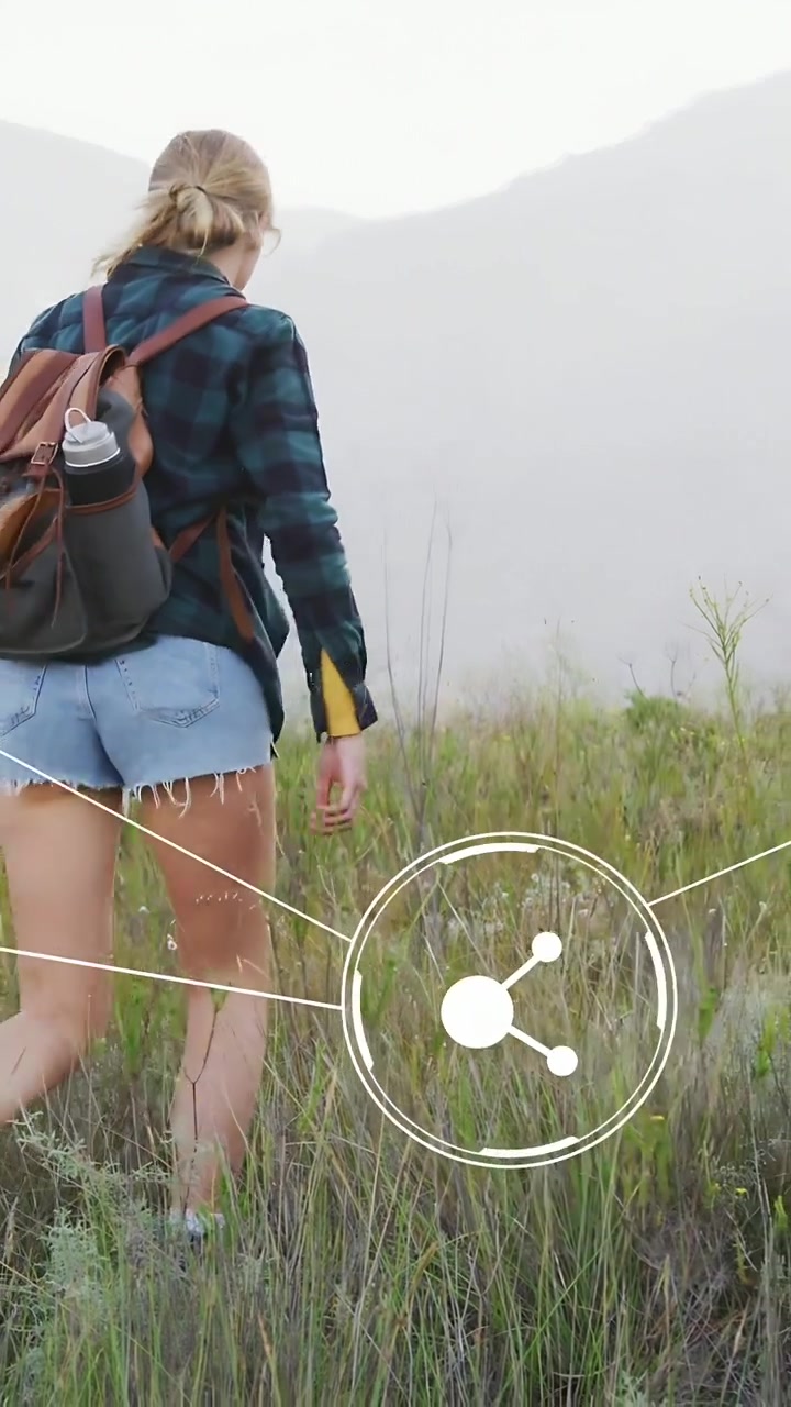 Vertical video: Woman hiking to misty peaks, stepping and animating nodes following her for tech