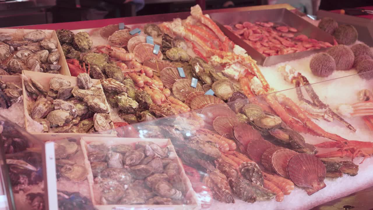 Scallops, Oysters, Shrimp, Prawns, Clams, Crab Legs, And Sea Urchins Display At The Fish Market In Bergen, Norway. - closeup shot