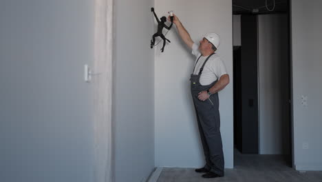 an electrician screws a light bulb into a monkey lamp.