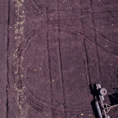 aerial view of tilled agricultural field with tractor