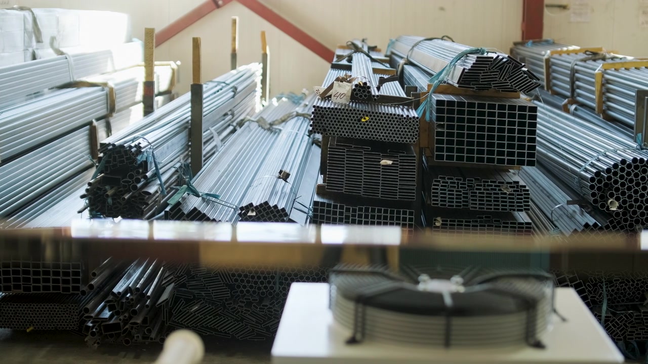 Pile di tubi e profili metallici in un magazzino industriale