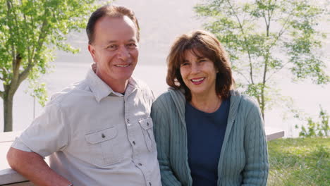 senior mixed race couple at a park looking to camera