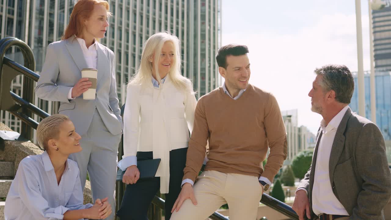 Group of business professionals having a conversation outside an office building