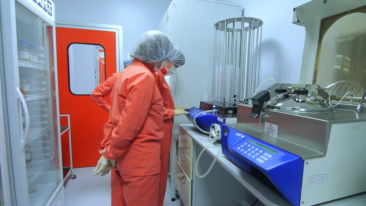 Pharmaceutical manufacturing workers check factory equipment