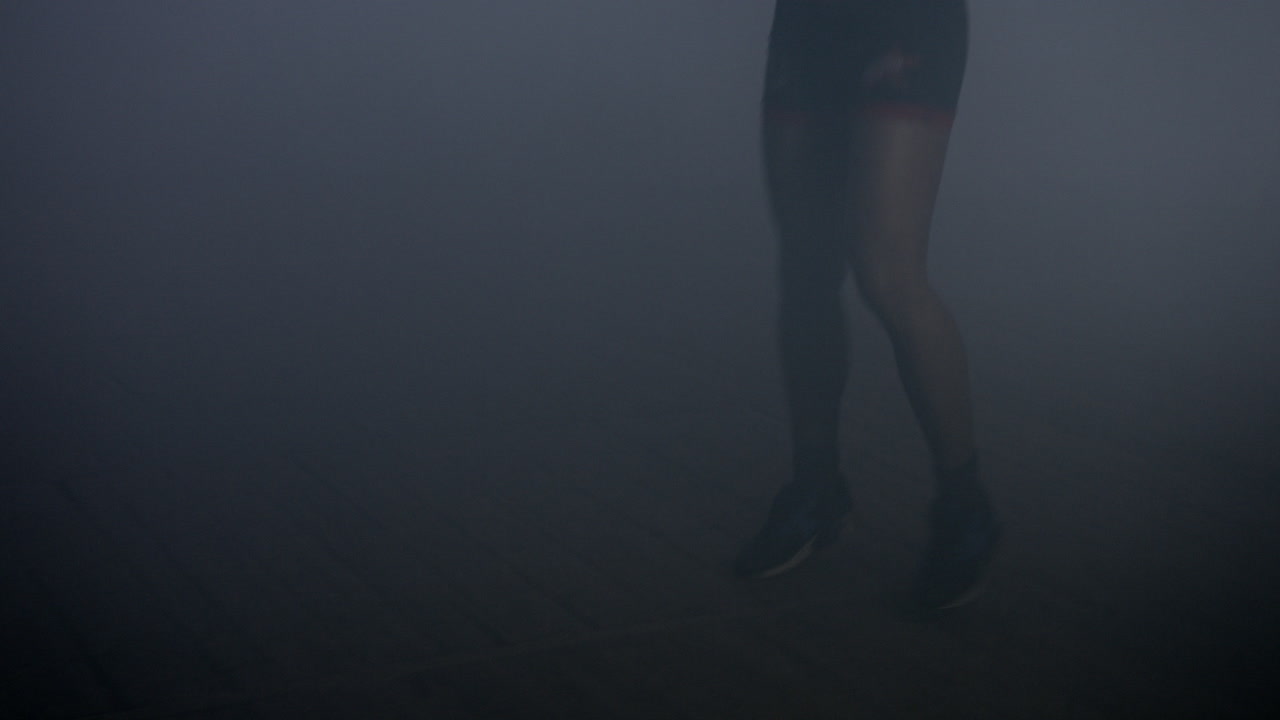 la silueta del luchador corre en un estudio oscuro. el luchador de artes marciales mixtas antes de la pelea