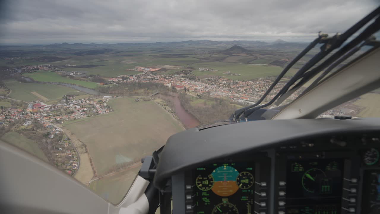 vista en primera persona dentro de la cabina del helicóptero bell 249 mientras vuela sobre el paisaje rural