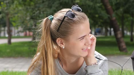 young couple listening to music in park