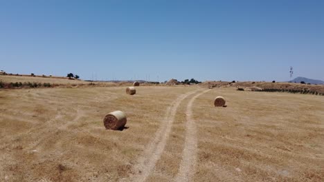 round straw bales in cyprus farmland fields, aerial dolly shoot