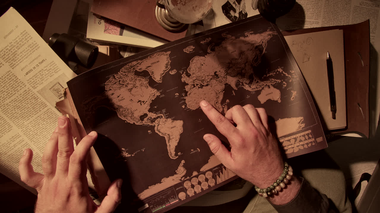 Person looking at a world map on a cluttered desk