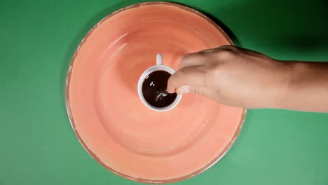 disparo en la cabeza: una cuchara, pesada con azúcar de caña, flotó sobre una taza de café negro humeante en un plato
