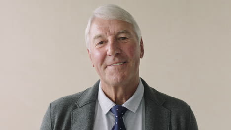 portrait of serious elderly businessman smiling standing wearing suit