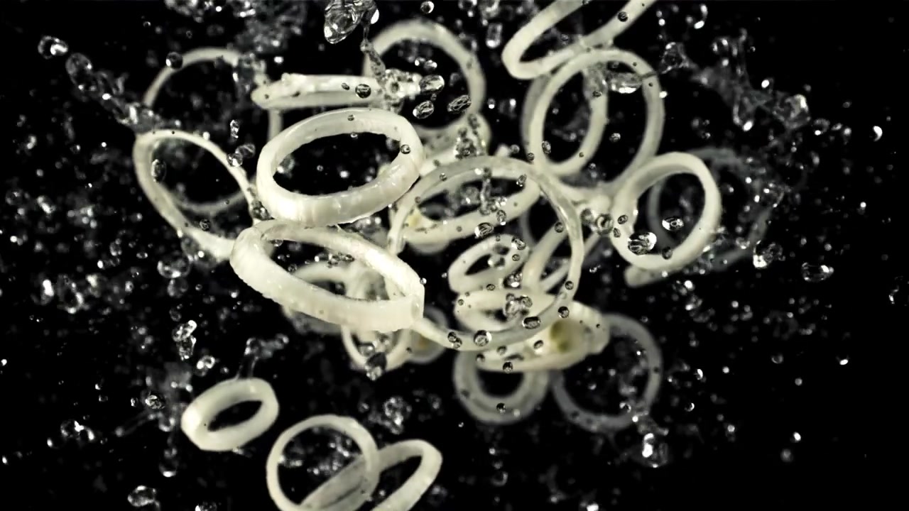 Gerak Lambat Cincin Bawang Terciprat Air di Latar Belakang Hitam