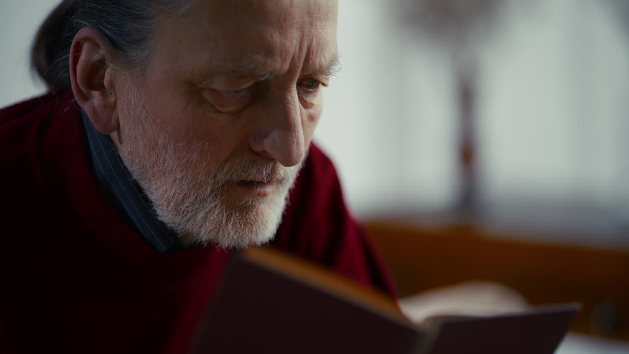 Close-up of Elderly Man with White Beard Reading a Book