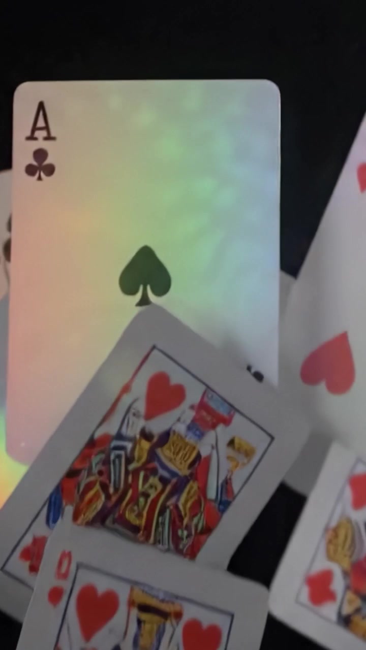 Cartas Caindo: Uma Exibição Cativante de Cartas de Baralho em Movimento com Reflexos de Luz e um Toque de Cor Contra um Fundo Escuro