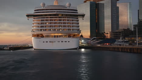 large cruise ship docked at city harbor during evening