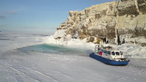 hovercraft on frozen lake near rocky coast