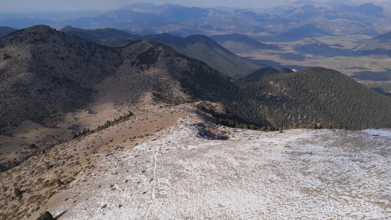 el descenso aéreo sigue un empinado sendero de montaña cubierto de nieve en las montañas del peloponeso de grecia.