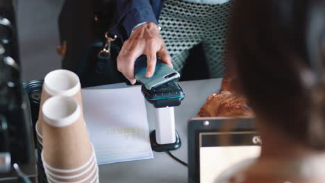 customer paying using smartphone contactless payment in cafe enjoying service spending money at restaurant