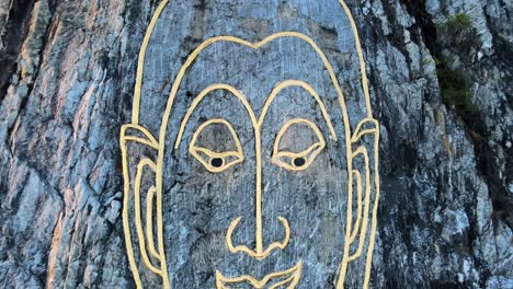 4k-Nahaufnahme-Drohnenaufnahme:-Bild-Von-Buddhas-Gesicht,-Eingraviert-Mit-Gold-In-Den-Hügel-In-Khao-Chi-Chan,-Thailand