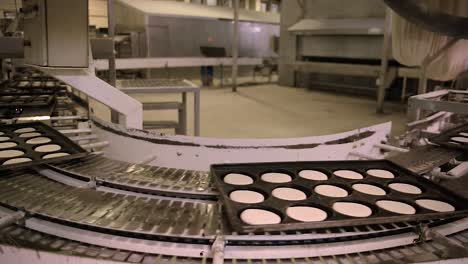 time-lapse of trays of dough transferred automatically inside bread factory