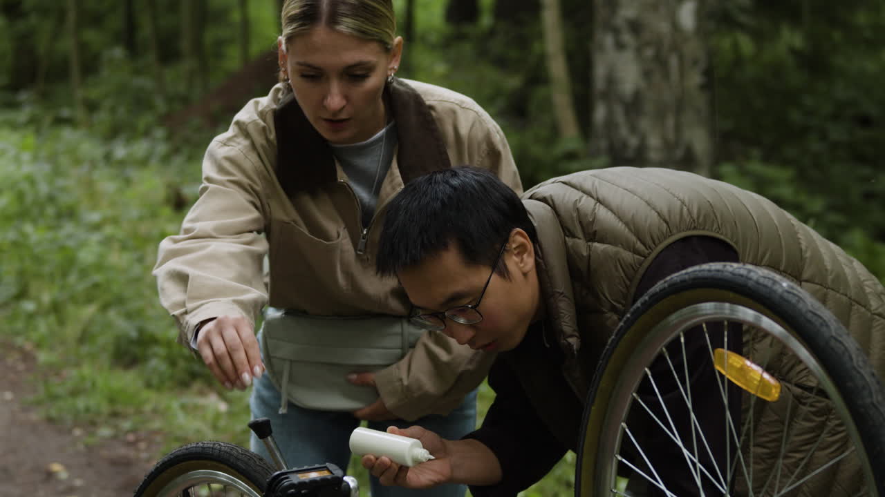 People fixing a bicycle outdoors