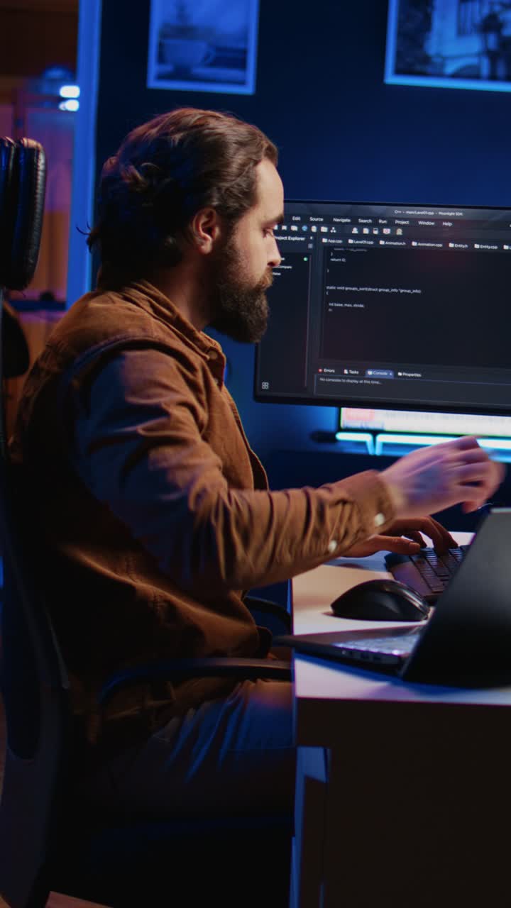 Focused Programmer Typing Code on Computer in Dark Office