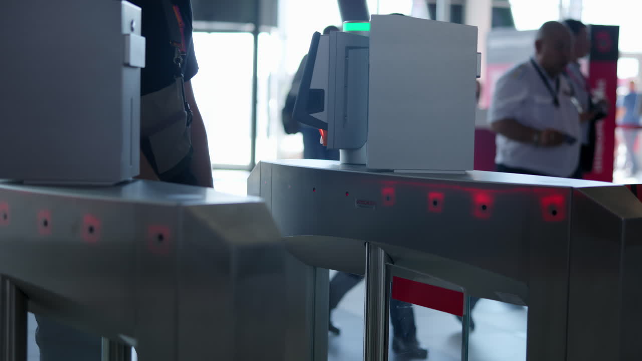 People passing through automatic turnstiles at a public entrance