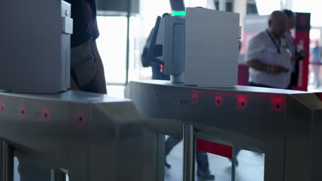 people passing through automatic turnstiles at a public entrance