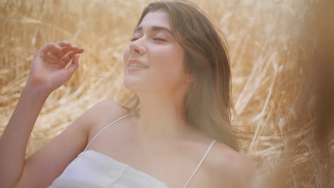 country lady rest spikelets nature portrait. relaxed girl posing on rural field