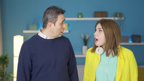padre y su joven hija adulta mirando a la cámara, están asombrados.