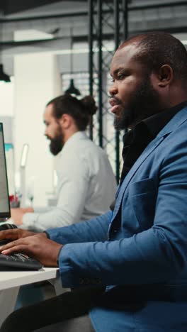 vertical video african american office worker leverages analytics and report writing