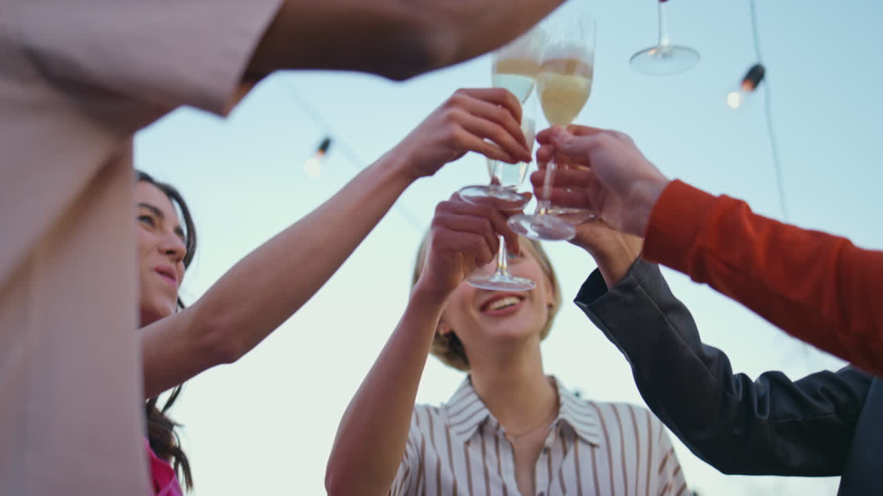 amigos multiétnicos haciendo sonar vasos en la naturaleza de cerca. grupo bebiendo alcohol