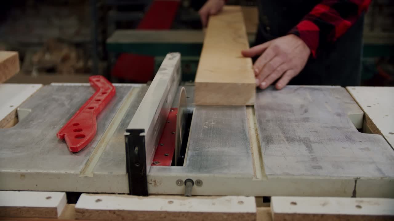 de cerca. el maestro corta una tabla de madera con una sierra circular en el taller de carpintería de un pequeño fabricante de muebles. cámara lenta. v3