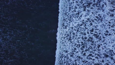 aerial-bird's-eye-view-of-sea-waves-passing-by-and-swimmers-4