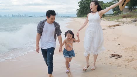 asian family walking at beach with kids happy vacation concept