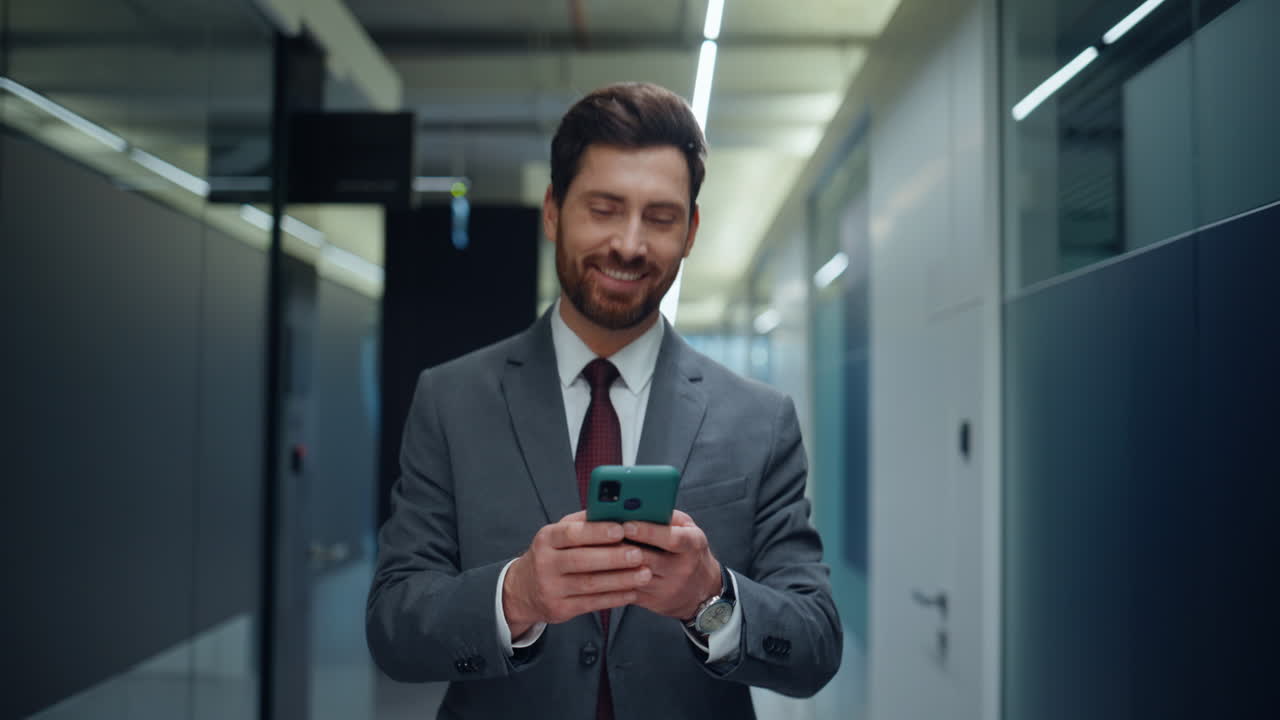 Bearded accountant sending sms on mobile phone looking watches on go closeup