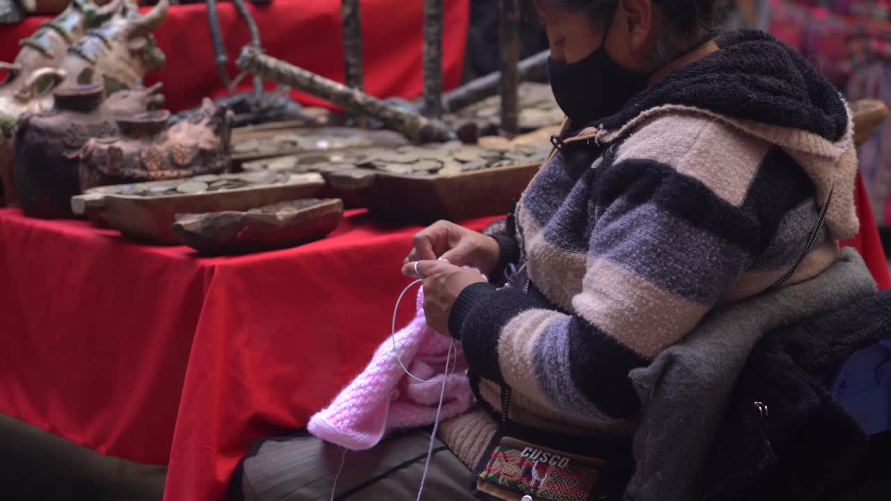 Peruvian Woman Sewing Wool Clothing With Hands In Cusco, Peru. medium shot