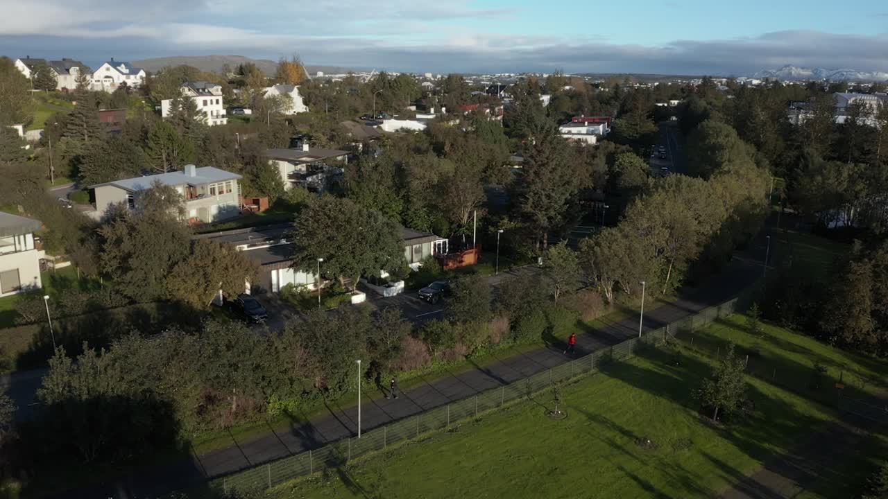 barrio suburbano en reykjavik con gente al aire libre, puesta de sol