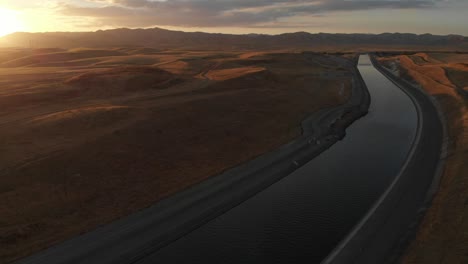 Antena-De-Izquierda-A-Derecha-Cerca-De-La-Puesta-Del-Sol-Sobre-El-Suministro-De-Agua-Dulce-Del-Acueducto-A-Las-Granjas-Y-Personas-De-California