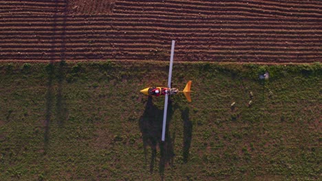 White-blades-on-gyrocopter-start-spinning-ready-for-take-off,-top-down