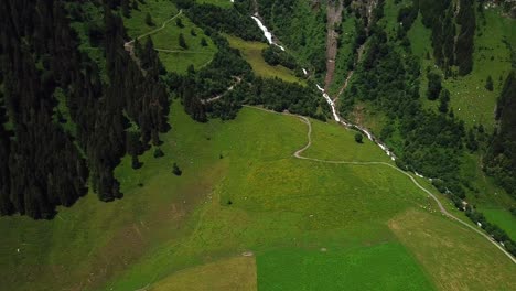 toma aérea de la cascada walcherfall, ferleiten, austria, fluyendo cerca de un sendero de montaña