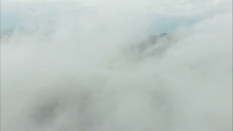 aerial - flying through clouds over snow landscape