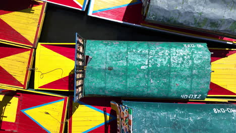 Birds-eye-drone-shot-above-Trajinera-boats-at-the-Xochimilco-Lake,-in-Mexico