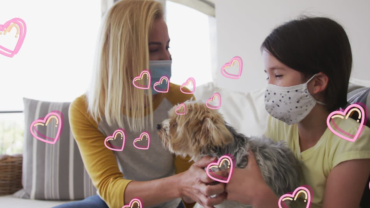 animación de corazones sobre mujer caucásica y su hija con máscaras faciales jugando con un perro mascota