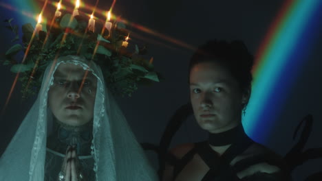 creative portrait of man with candle wreath and woman in feathers