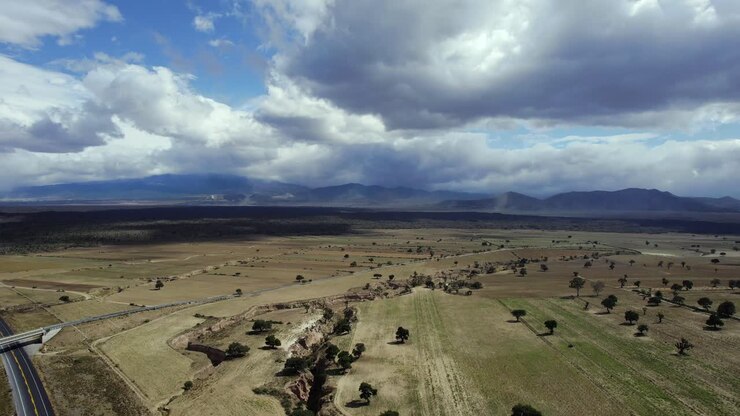 Veduta aerea di un terreno agricolo arido nello Stato del Messico, Messico, attraversato da un'autostrada.