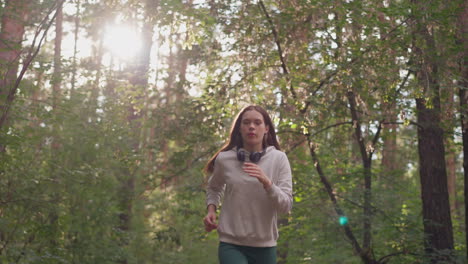 atleta mujer corriendo en el bosque. ejercicio cardio para mejorar la resistencia y el cuerpo tonificado. entrenamiento de fitness profesional en la naturaleza en un día soleado de verano